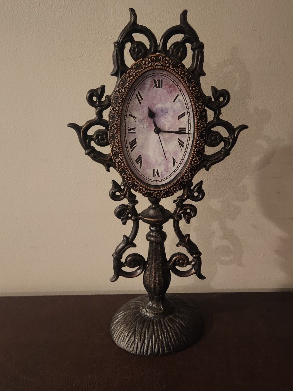 Vintage decorative mantle clock features an ornate metal leaf or vine design